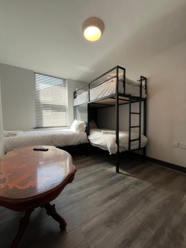 a room with two bunk beds and a table at 80 Anfield house in Liverpool