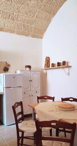 a kitchen with a table and chairs and a refrigerator at Casa Tricase Porto - 20 meters from the sea in Marina Serra