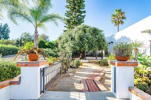 a garden with palm trees and a fence at Luxury 5 bedroom Wine Retreat Fallbrook Villa sleeps 12 in Fallbrook