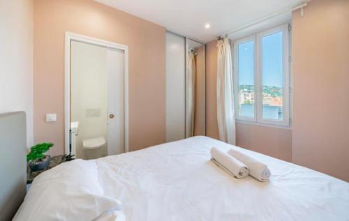 une chambre avec un lit blanc avec deux serviettes dessus dans l'établissement Close to train station and palace, quiet, à Cannes