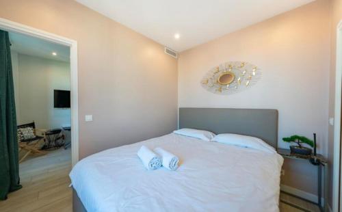 - une chambre avec un lit blanc et un miroir mural dans l'établissement Close to train station and palace, quiet, à Cannes