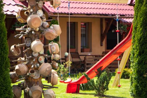 a tree with pots and pans on it with a slide at Patakmenti Panzió Spa in Corund