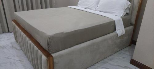 a bed with a white pillow on top of it at Serene BnB - Apt 06 Makongo after Mlimani City in Dar es Salaam