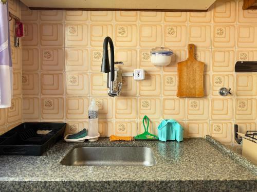 a kitchen counter top with a sink and a counter top at Kitnet na praia Aviação, Wi-Fi e garagem! in Samaritá