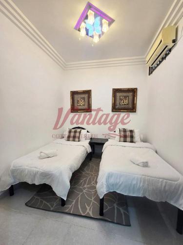 a room with two beds and a sign on the wall at Vantage Cottage in Jertih