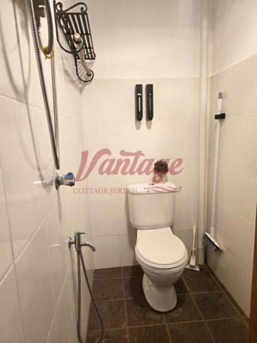 a bathroom with a toilet with a sign on the wall at Vantage Cottage in Jertih
