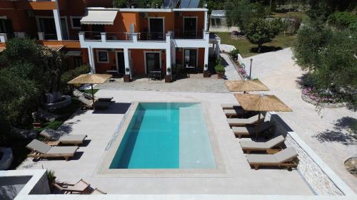 Una vista aérea de una piscina con sillas y sombrillas. en Grigoris Garden, en Parga