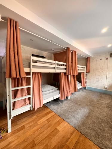 een kamer met 4 stapelbedden en oranje gordijnen bij Samba Guesthouse in Porto