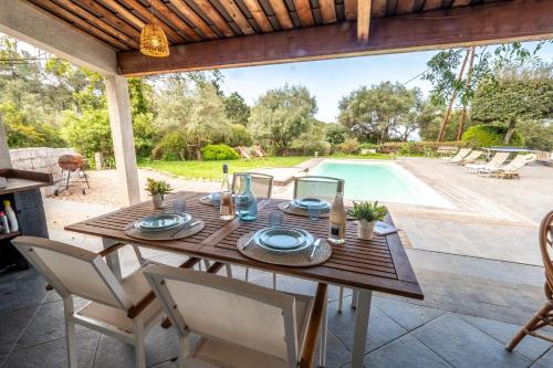 une table et des chaises en bois sur une terrasse avec une piscine dans l'établissement Altimare - Pool Terrace Relaxing stay - by TGB, à Pietrosella