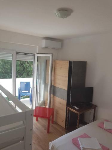 a bedroom with a bed and a flat screen tv at Apartmani Dream 3 in Šušanj