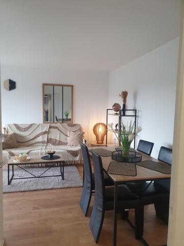 un salon avec une table et un canapé dans l'établissement Carnac, à Montigny-le-Bretonneux