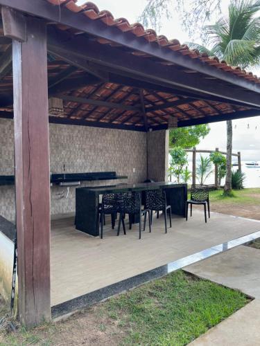 a patio with a table and chairs under a pergola at Flete Pé na Areia - Barra Grande in Marau