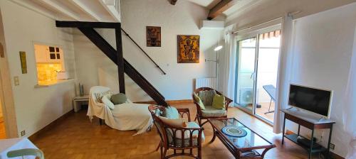 - un salon avec des chaises, une télévision et un canapé dans l'établissement Charming accommodation with pleasant terrace, à Saint-Raphaël