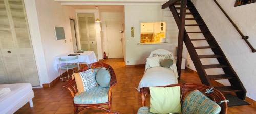 un salon avec deux chaises et un escalier dans l'établissement Charming accommodation with pleasant terrace, à Saint-Raphaël