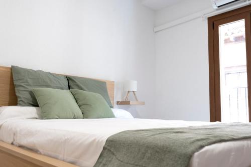 トレドにあるHabitación Independiente Cristo de la luzの白いベッドルーム(緑の枕が付くベッド付)