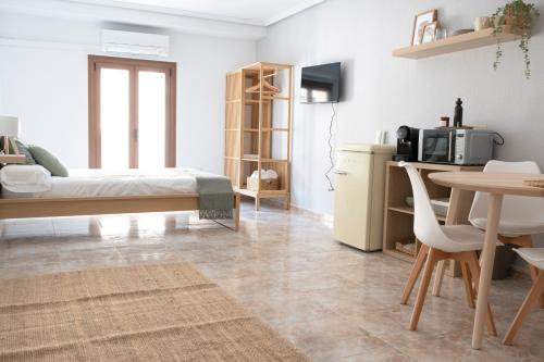 トレドにあるHabitación Independiente Cristo de la luzのリビングルーム(ベッド1台、テーブル付)、キッチンが備わります。