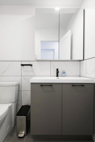 a white bathroom with a sink and a toilet at Bromont Lodge 837 shefford suite 200 in Bromont