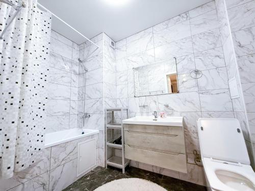 a white bathroom with a sink and a mirror at ЖК Nomad KZ Almaty in Zhezdi
