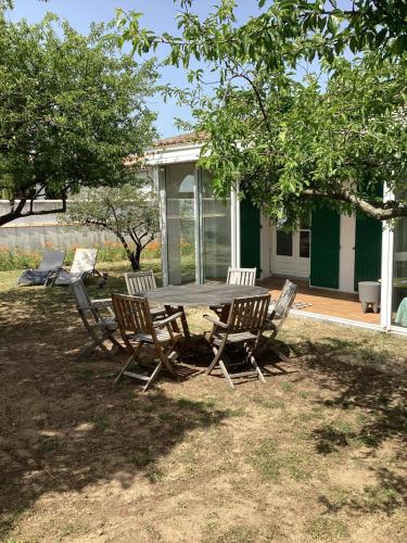 - une table de pique-nique et des chaises en face d'une maison dans l'établissement Maison sainte marie de ré, à Sainte-Marie de Ré