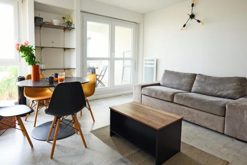 un salon avec un canapé et une table dans l'établissement Appartement Melgueil - Welkeys, à La Grande Motte