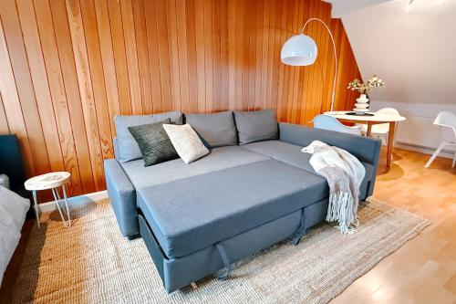 ein blaues Sofa im Wohnzimmer mit einem Tisch in der Unterkunft Rooftop-Apartment zentral gelegen in Düsseldorf in Düsseldorf