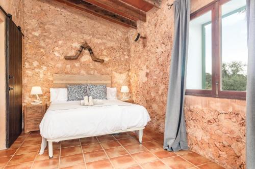 ein Schlafzimmer mit einem Bett in einer Steinmauer in der Unterkunft Casa Antigua in Santanyi
