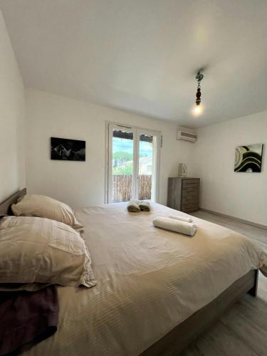 une chambre avec un grand lit avec deux serviettes dessus dans l'établissement Villa 4 Chambres Clim Piscine Parking 15 Min Plage, à Fabrègues