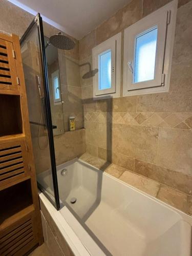 une salle de bain avec baignoire et douche en verre dans l'établissement Villa 4 Chambres Clim Piscine Parking 15 Min Plage, à Fabrègues