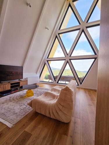 ein großes Wohnzimmer mit einem großen Fenster in der Unterkunft Ilinca Chalet in Botiza