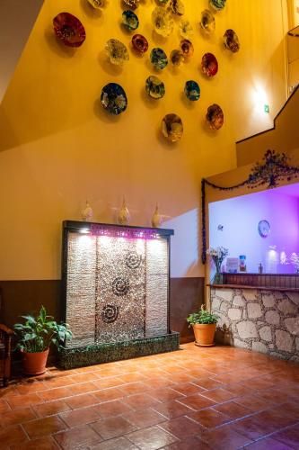 a room with a fireplace with plates on the wall at Hotel Estefania in Morelia