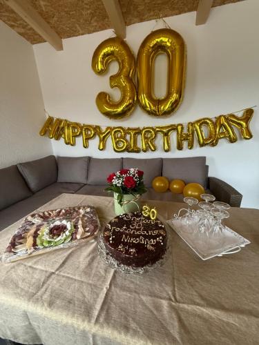 a table with a cake and a happy birthday sign at Kuća za odmor Villa Kovačević in Bihać