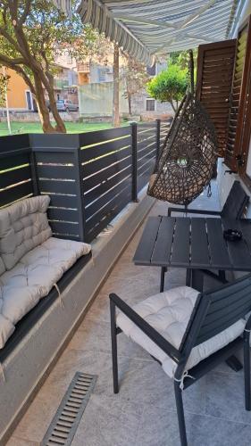 a patio with a hammock and a table and a swing at Apartments Pepe in Novigrad Istria
