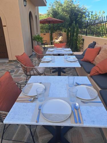 a table with plates and utensils on a patio at Boutique Hotel Caramel in Syvota