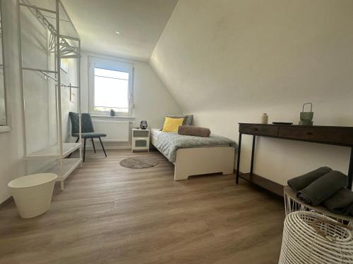 a bedroom with a bed and a desk and a window at NeckarNest Ferienwohnung in Neckarwestheim