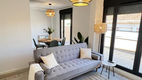 a living room with a couch and a table at Apartamenticos Living San Pablo in Zaragoza