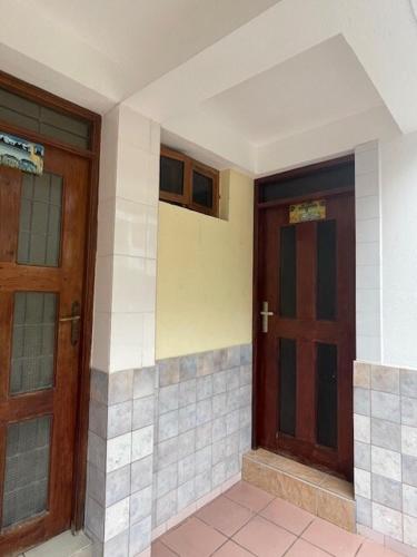 two wooden doors in a building with tiled floors at Mikocheni Comfort I Dar es Salaam, Tanzania in Dar es Salaam