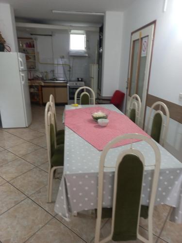 a dining room table with a pink and white table cloth at Hostel Bata in Kanjiža
