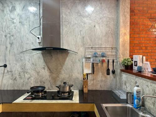a kitchen with a stove and a sink at City House Don Mueang Airport Bangkok in Don Muang Airport