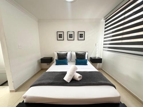 a bedroom with a large white bed with blue pillows at Beautiful house with a pool in Pereira in Pereira