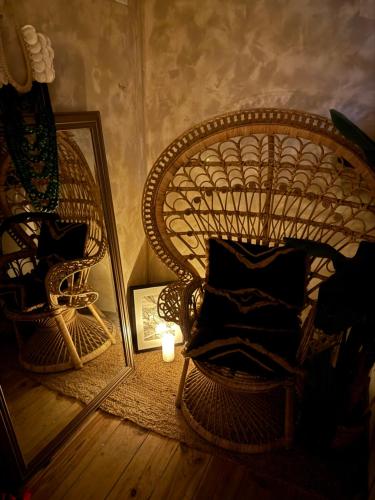 une chaise en osier avec une bougie et un miroir dans l'établissement Moment Aixois, à Aix-en-Provence