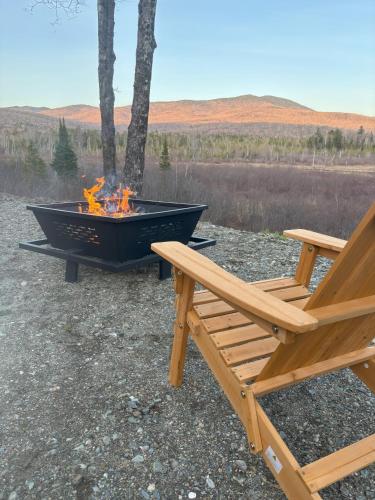 a fire pit and two chairs sitting next to a bench at Belvidere Mountain Vista Home by Stowe Jay Peak Smuggs Long Trail in Belvidere Center