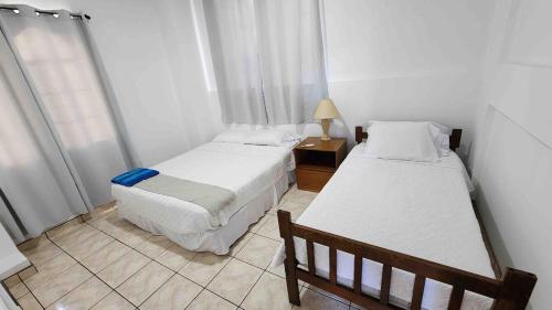 TamaniqueにあるCasa Tropical Kaylaniのベッドルーム1室(ベッド2台、ランプ付きテーブル付)