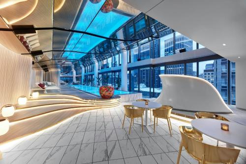 a lobby with tables and chairs in a building at W Melbourne in Melbourne