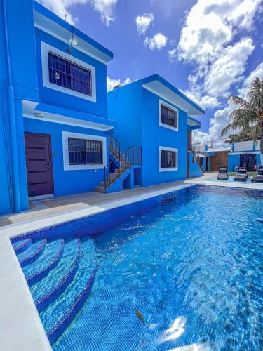 a blue house with a swimming pool in front of it at Rainbow Suites in Cozumel
