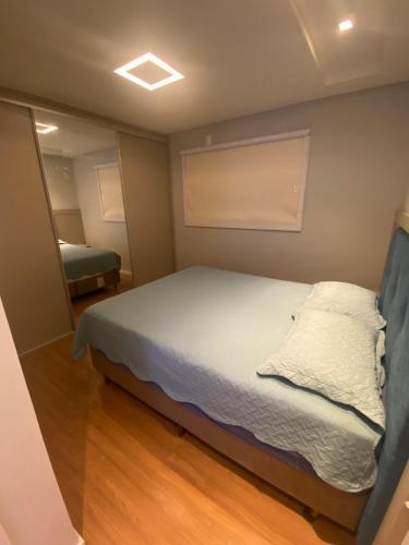 a small bedroom with a bed and a chair at Ap Ideal Para se Sentir Em Casa, Trabalho ou Lazer in Itajaí