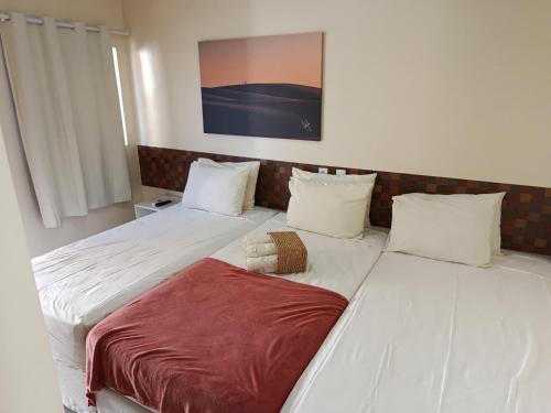 two beds sitting next to each other in a room at POUSADA DOS LAGOS in Paulino Neves