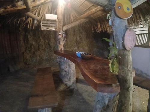 a room with a tree stump table in a cave at Casa chololo in Mazunte