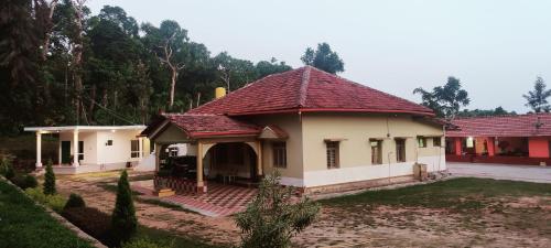 a small house with a red roof at Malnad Bliss in Sringeri