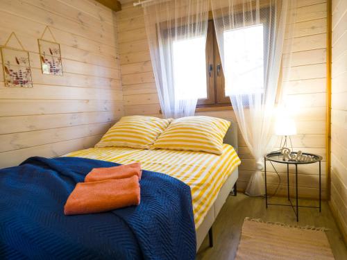 a bedroom with a yellow and blue bed and a window at Leśne Dziady Borsk in Borsk