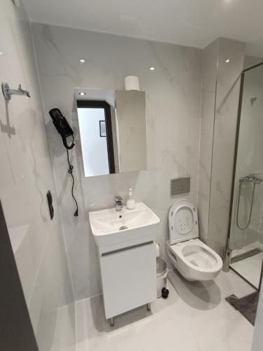 a white bathroom with a sink and a toilet at kallithea maisonette in Kallithea Halkidikis